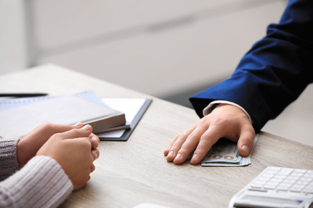 Man taking bribe money at table indoors, closeup