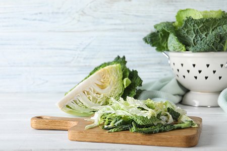 Cut fresh savoy cabbage on white wooden tableの写真素材