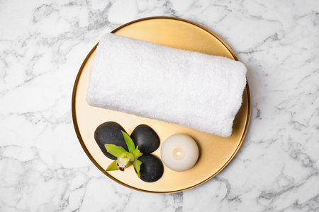 Tray with towel and spa stones on white marble table, top viewの写真素材