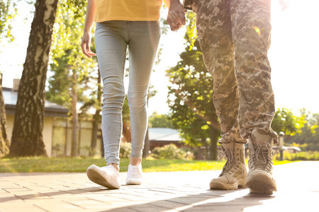 Man in military uniform walking with his girlfriend at sunny park, closeupの写真素材