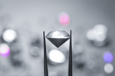 Tweezers with beautiful gemstone on blurred backgroundの写真素材