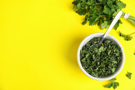 Flat lay composition with fresh and dried parsley on yellow background. Space for textの写真素材