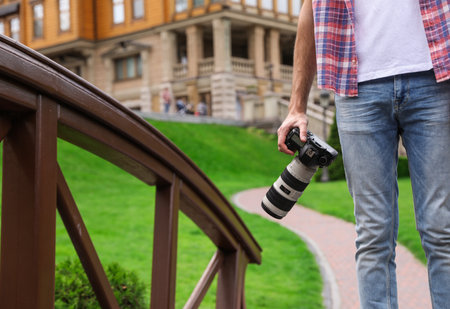 Photographer with professional camera in park, closeupの写真素材