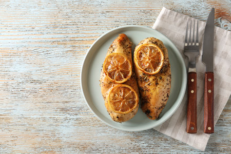 Delicious lemon chicken served on wooden table, flat layの写真素材