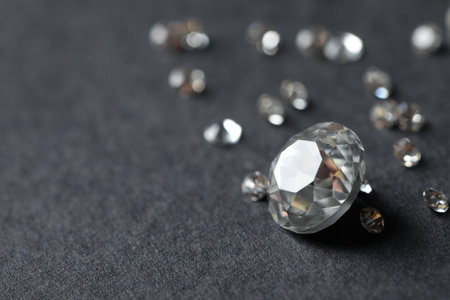 Beautiful gemstones for jewelry on gray background, closeup. Space for text