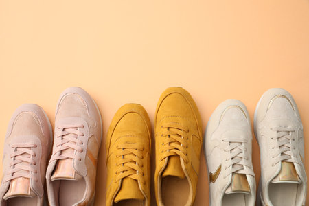Different stylish shoes on orange background, flat lay. Space for textの写真素材