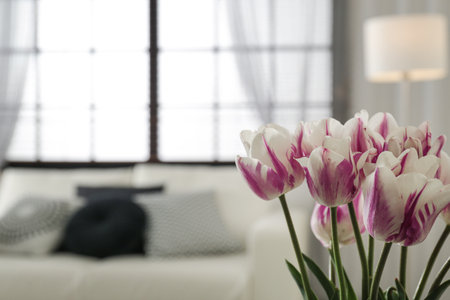 Blurred view of modern room interior, focus on fresh flowersの写真素材