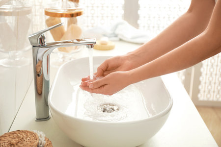 Woman washing hands indoors, closeup. bathroom interiorの写真素材