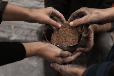 Poor homeless people with pieces of bread outdoors, closeupの写真素材