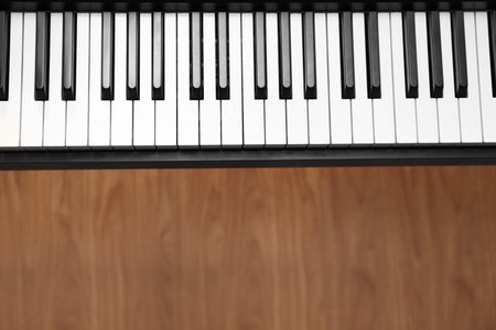 Modern piano with black and white keys over floor, top view. Space for textの写真素材