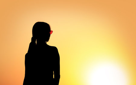 Silhouette of a young woman outdoors at sunsetの写真素材