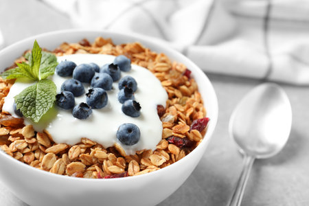 Delicious yogurt with granola and blueberries served on gray table, closeupの写真素材