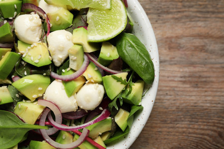 Delicious avocado salad with mozzarella on wooden table, top viewの写真素材