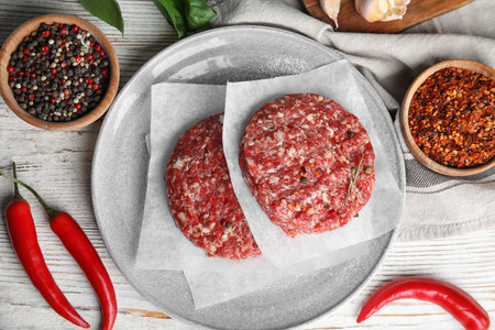 Flat lay composition with raw meat cutlets for burger on white wooden tableの写真素材