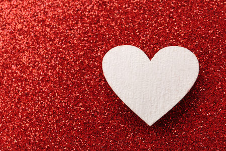 White wooden heart on red shiny background, top view. Space for textの写真素材