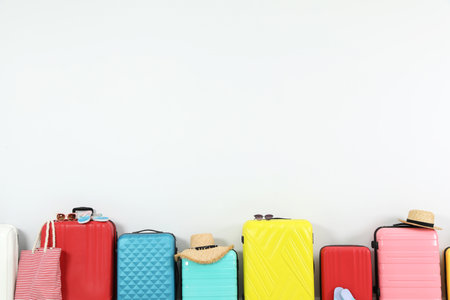 Trendy composition with colorful suitcases on light background. Space for textの写真素材