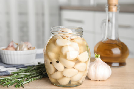 Composition with jar of pickled garlic on wooden table indoorsの写真素材