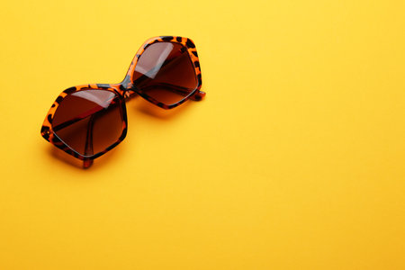 Stylish sunglasses on yellow background, space for text. fashion accessoryの写真素材