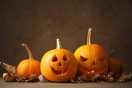 Composition with pumpkin heads on dark background. Jack lantern - traditional Halloween decorの写真素材