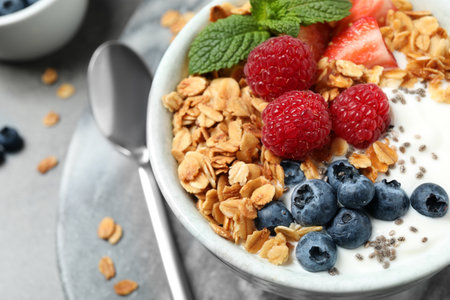 Tasty homemade granola with yogurt and berries on gray table, closeup. healthy breakfastの写真素材