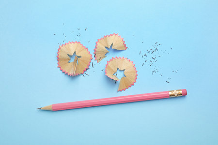 Pencil and shavings on blue background, flat layの写真素材