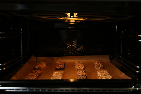 Delicious healthy granola bars on baking sheet in ovenの写真素材