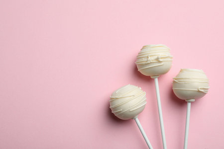 Sweet cake pops on pink background, flat lay. Space for textの写真素材