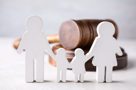 Figure in shape of people and wooden gavel on light table. family law conceptの写真素材