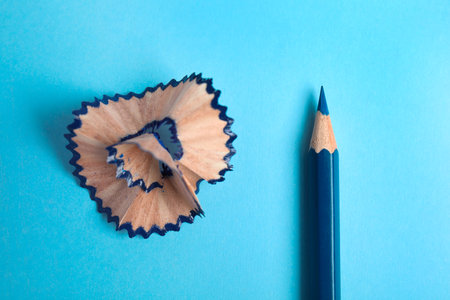 Color pencil and shaving on blue background, top viewの写真素材