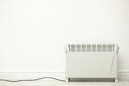 Modern electric heater near white wall indoors. Space for textの写真素材