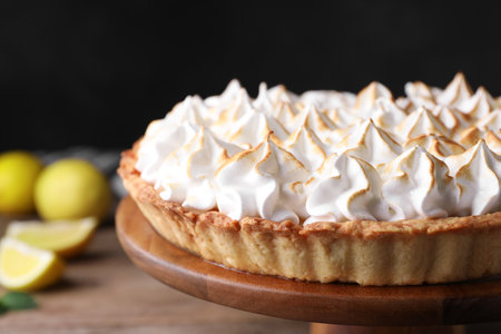 Stand with delicious lemon meringue pie on wooden table, closeupの写真素材