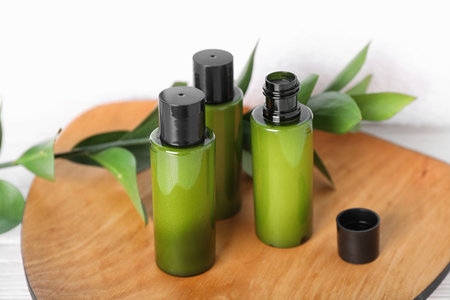 Mini bottles with cosmetic products on wooden plateの写真素材