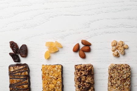 Healthy granola bars on white wooden table, flat lay. Space for textの写真素材