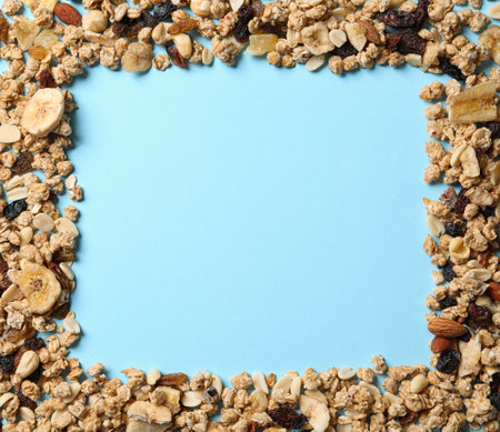 Frame made of ingredients for homemade healthy granola bars on blue background, flat lay. Space for textの写真素材