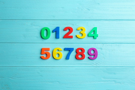 Colorful magnetic numbers on light blue wooden background, flat layの写真素材