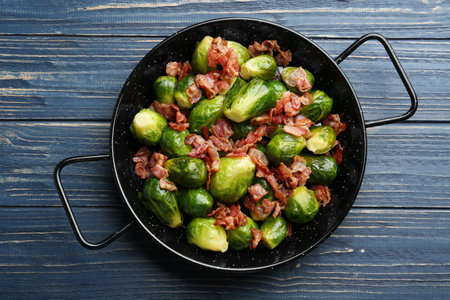 Tasty roasted Brussels sprouts with bacon on blue wooden table, top viewの写真素材