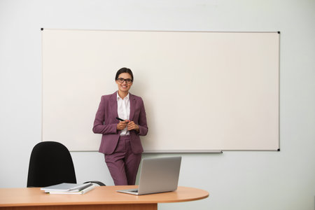 Female teacher near whiteboard in modern classroomの写真素材
