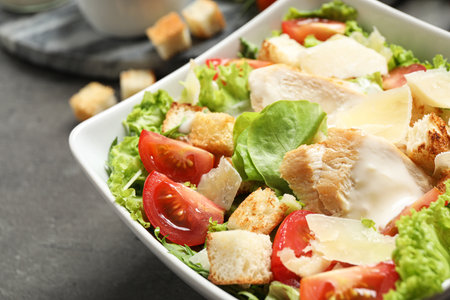 Delicious fresh Caesar salad in bowl on gray table, closeupの写真素材