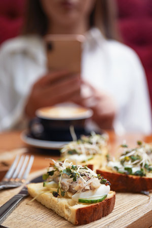 Food blogger taking photo of lunch in cafe, focus on delicious bruschettasの写真素材