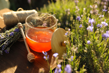Jar of honey on wooden table in lavender fieldの写真素材
