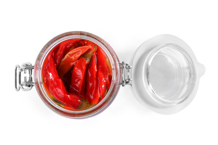 Open jar of pickled red hot chili peppers on white background, top viewの写真素材