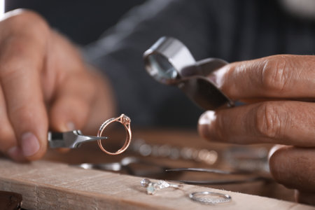 Male jeweler examining diamond ring in workshop, closeup viewの写真素材