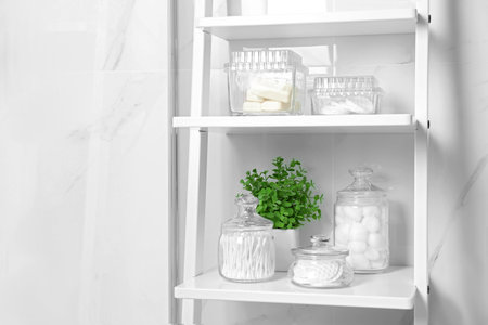 Cotton swabs and other hygiene products on shelving unit in bathroomの写真素材