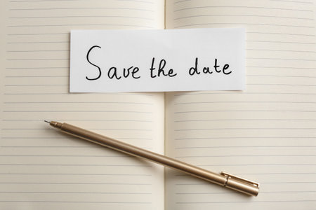 Piece of paper with phrase SAVE THE DATE on notebook, flat layの写真素材