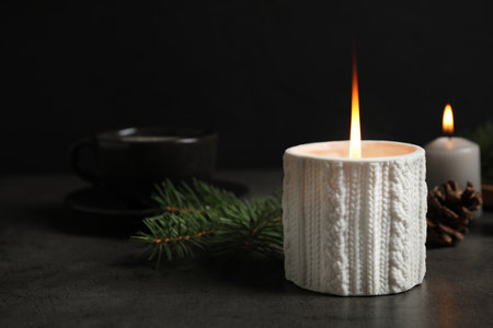 Candle and Christmas decor on dark gray table, space for textの写真素材