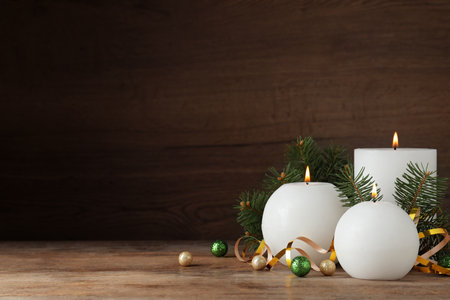 Beautiful Christmas composition with burning white candles on wooden background. Space for textの写真素材