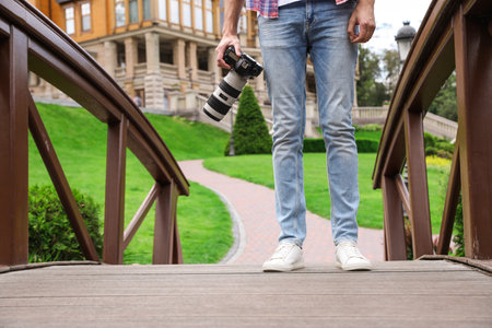 Photographer with professional camera in park, closeupの写真素材
