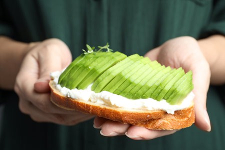 Woman holding tasty sandwich with avocado, closeupの写真素材