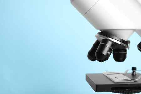 Closeup view of modern microscope on blue background, space for text. medical equipmentの写真素材