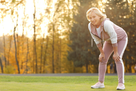 Happy mature woman resting after exercise outdoorsの写真素材